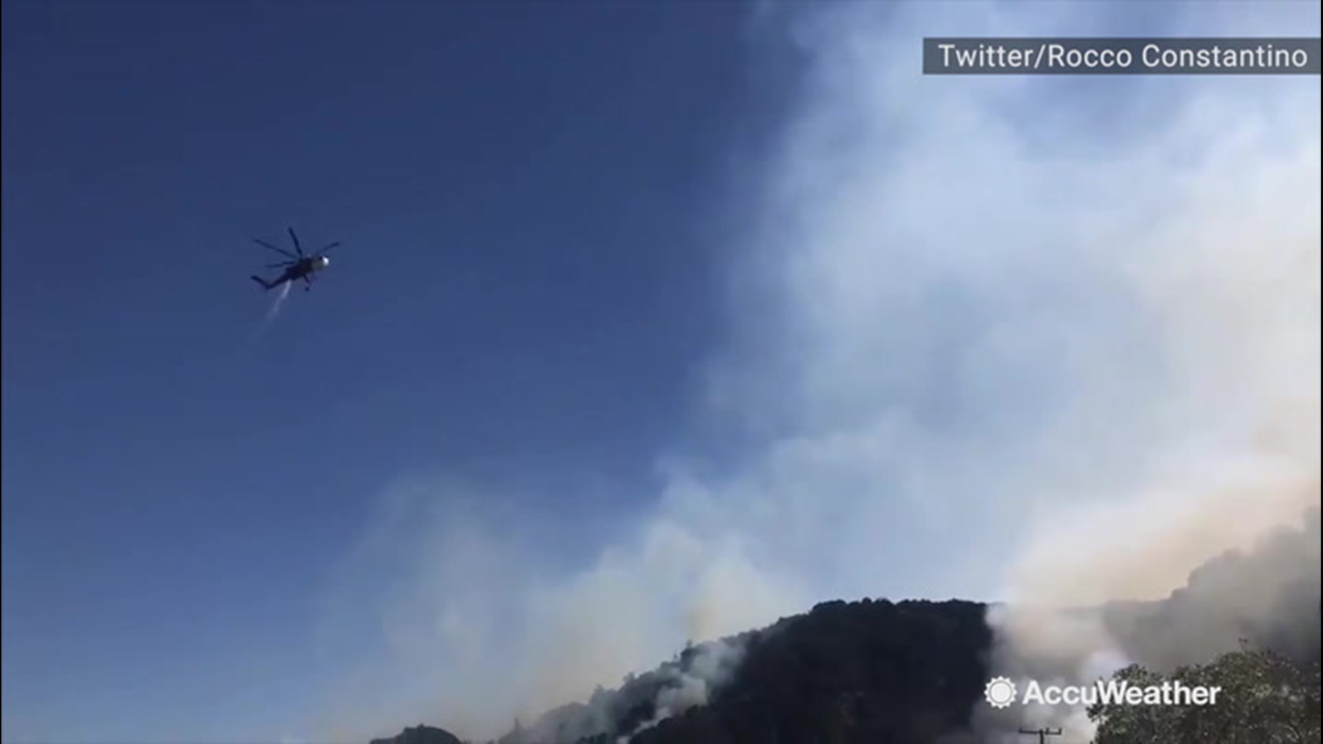 A wildfire broke out close to a highway in Santa Clarita, California, on Oct. 12. A helicopter was spotted dumping retardant on the wildfire to try and contain it.