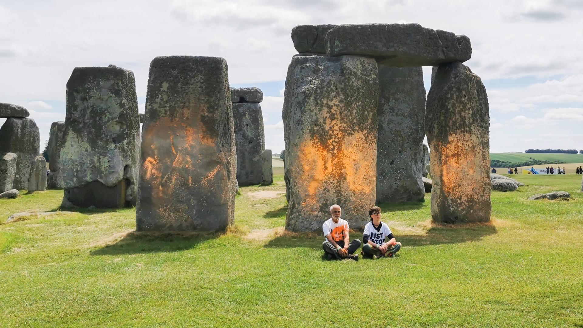 Two climate protesters were arrested on Wednesday after orange paint was sprayed on the ancient Stonehenge monument in southern England, police said.