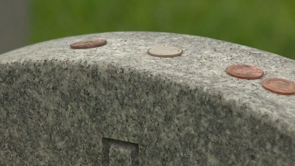 What do coins left on military gravestones mean?