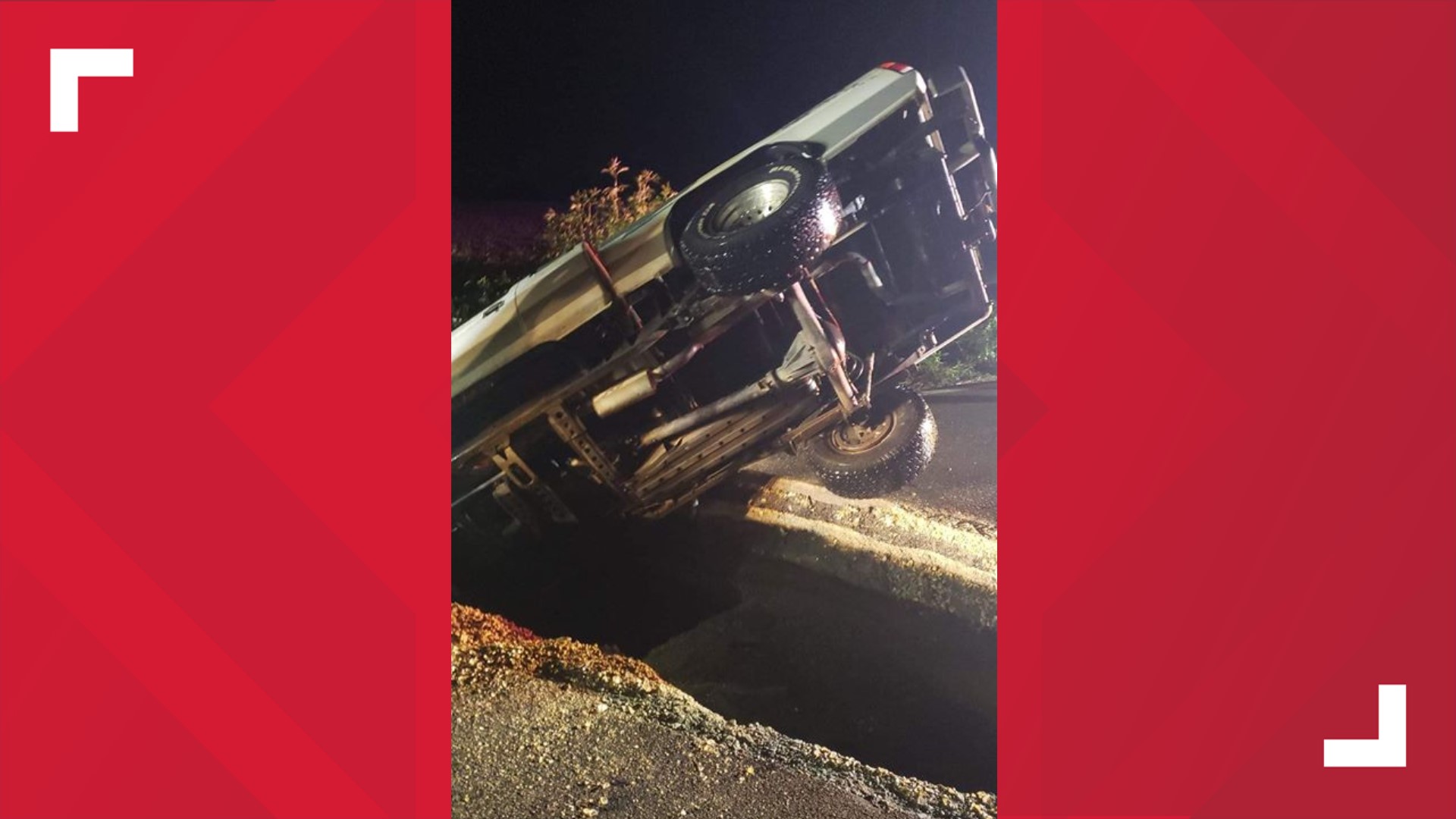 A truck toppled into a split in the road caused by heavy rains Sunday night.