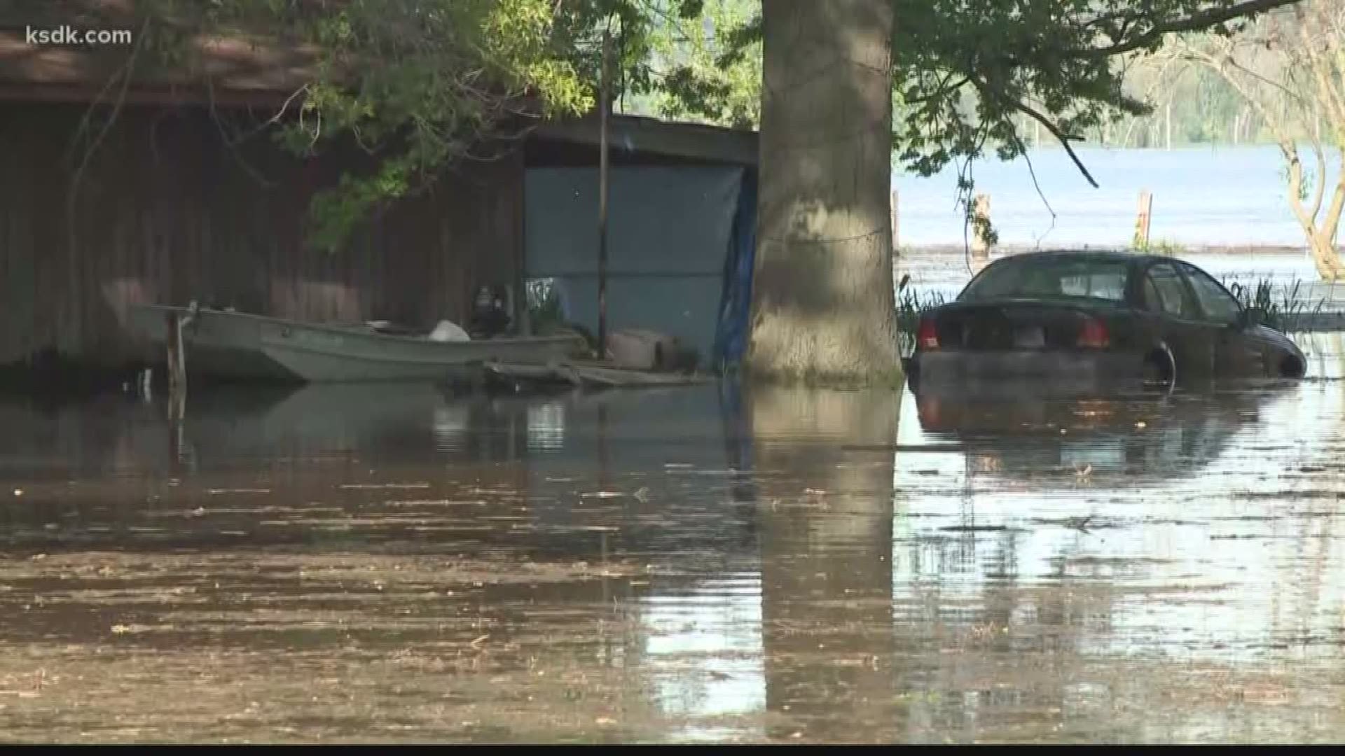 Sunday, as boats navigated by street signs, a small group of volunteers worked to reinforce weak spots in the town's secondary levee.