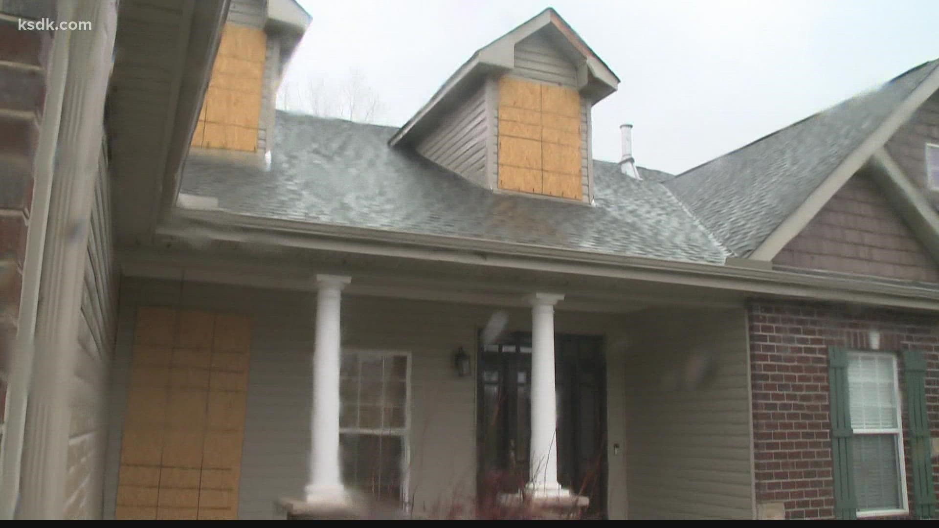 Houses along Red Barn Lane have tarps on the roofs, water damage and boarded windows four months after the storm hit.