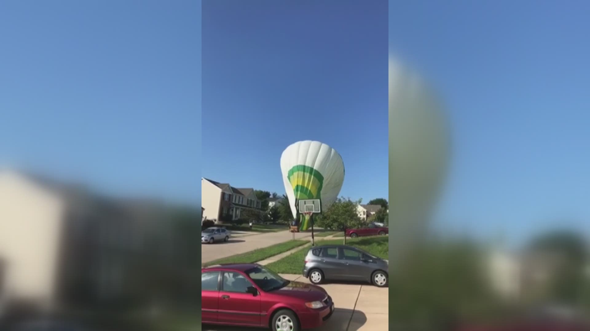 Photos and videos sent to 5 On Your Side show a large green, white and yellow hot air balloon sitting in the middle of a neighborhood street.