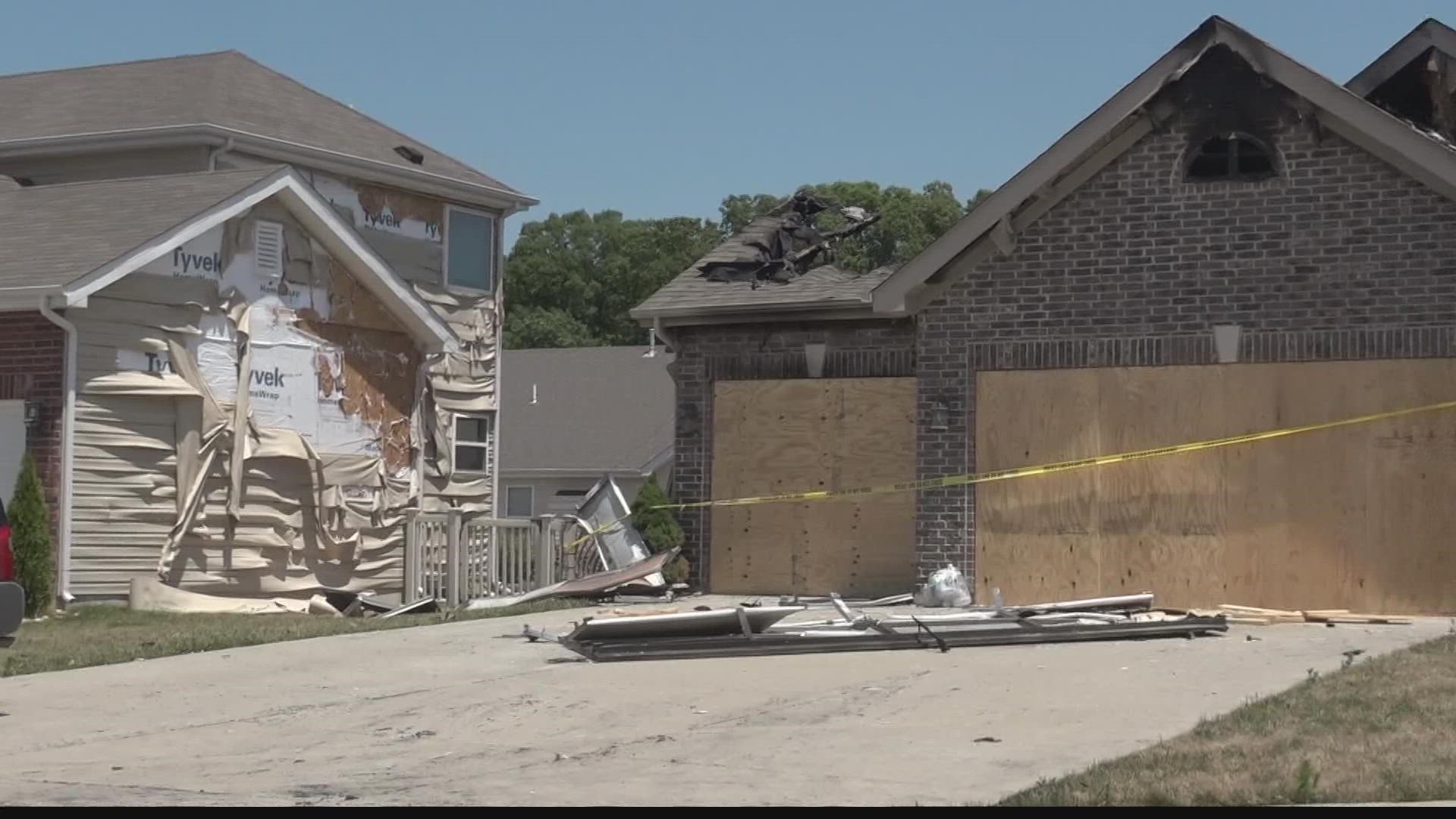 Smoldering fireworks debris stored near homes re-ignited forcing two families to be displaced, firefighters said.