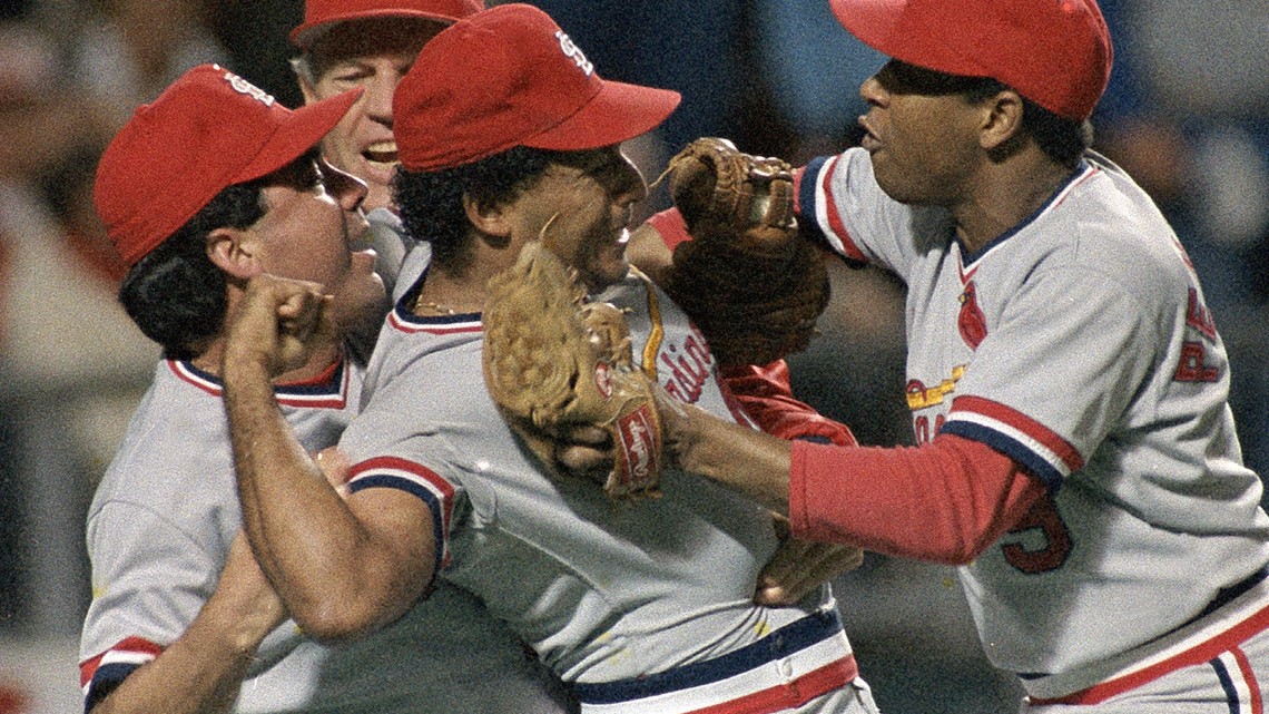 Joaquin Andujar of the St. Louis Cardinals being held back by