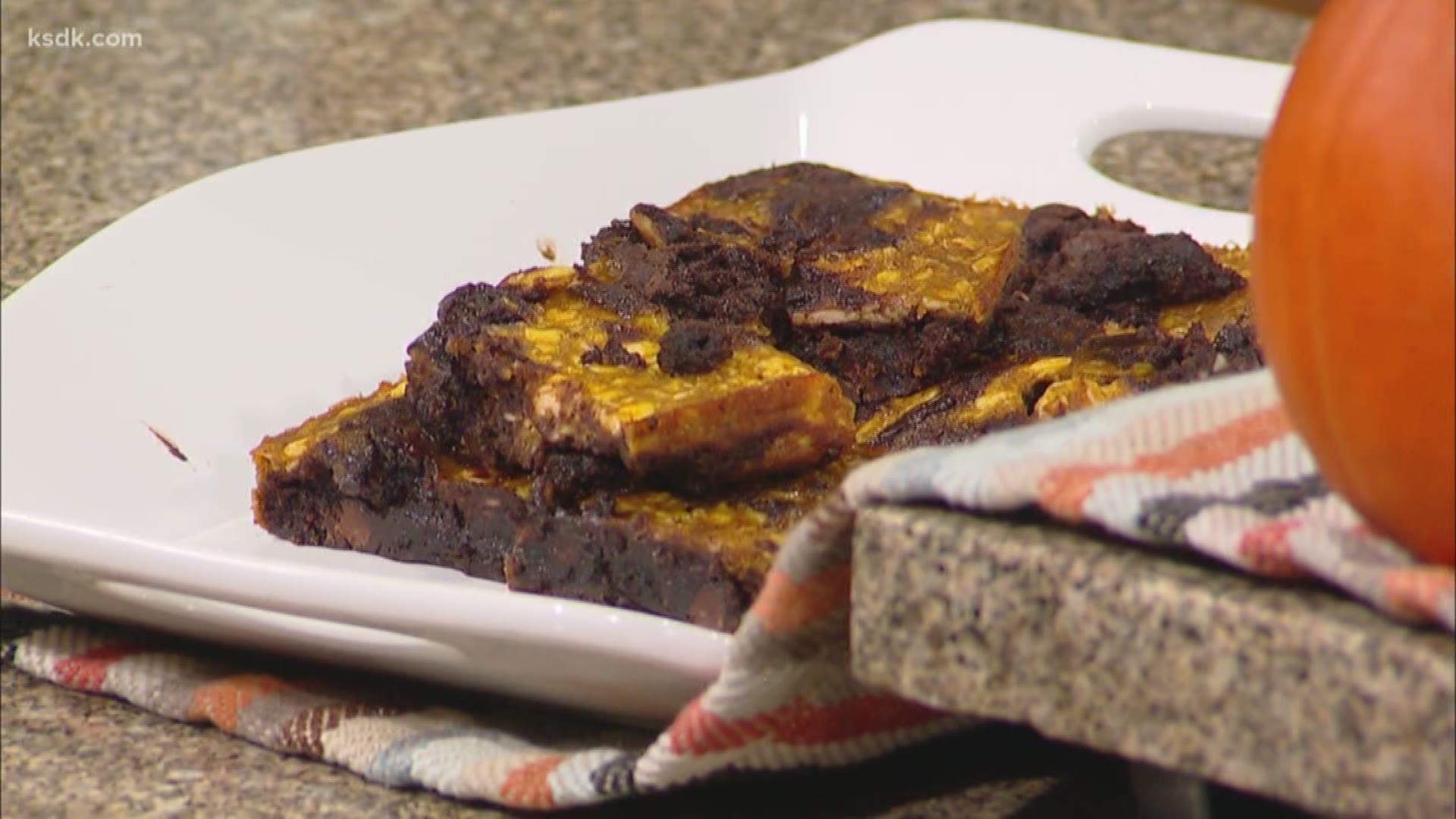 Hayley Sohn of Basically It Meals is gearing up for fall weather with these Gluten Free Pumpkin Cheesecake Brownies!