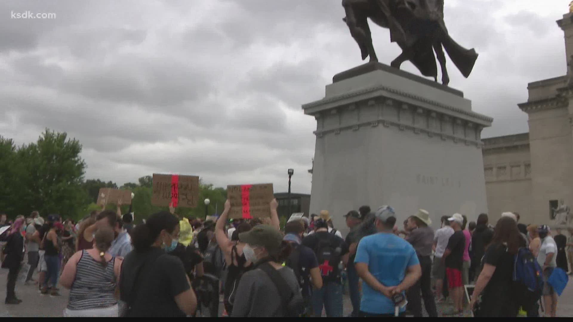 The rally kicked off around noon with hundreds of people. Some protesters used chalk to cross out the word "saint" and write what the statue means to them