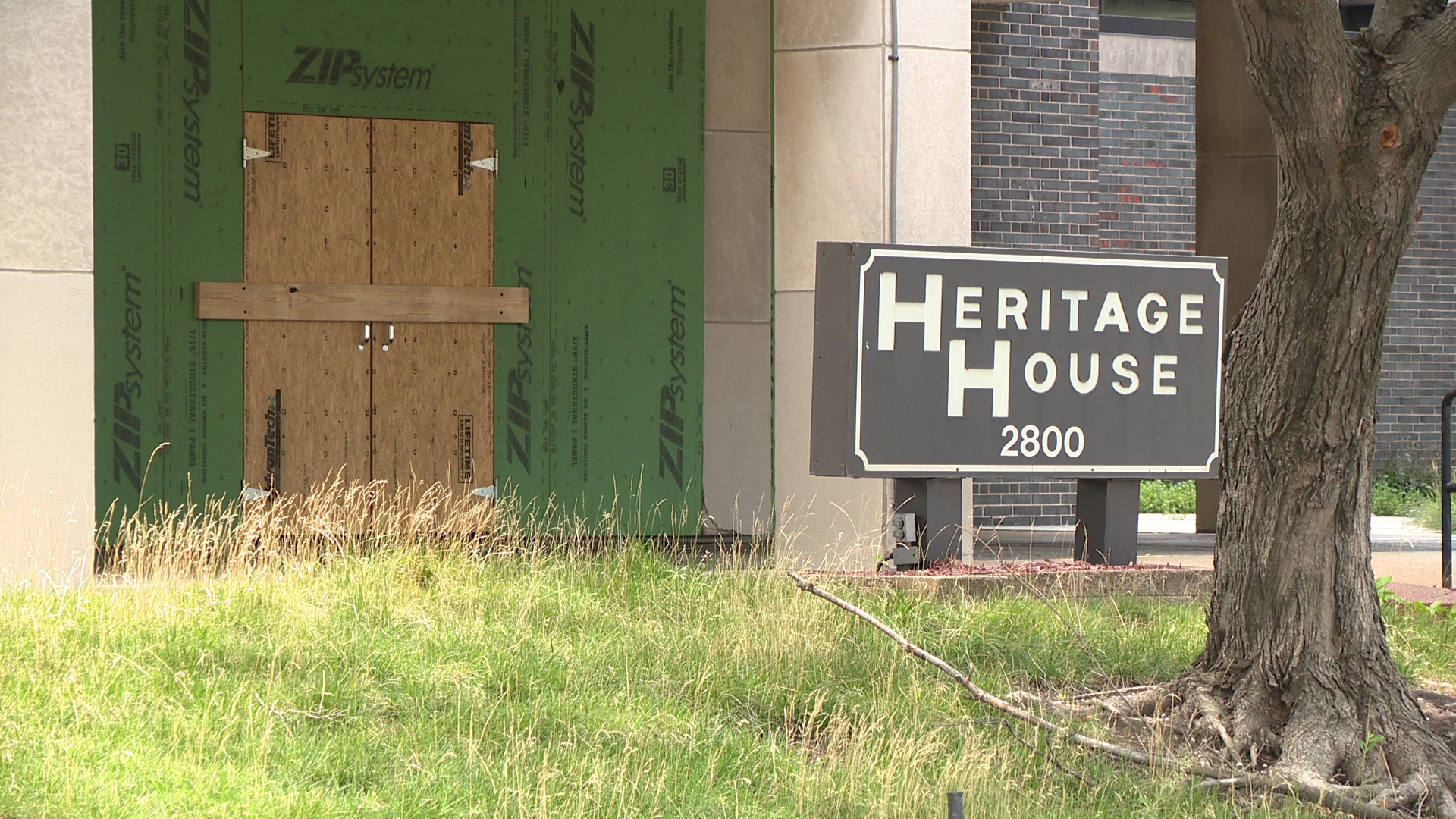 The former residential building has continued to degrade, with overgrown grass and windows still boarded up.