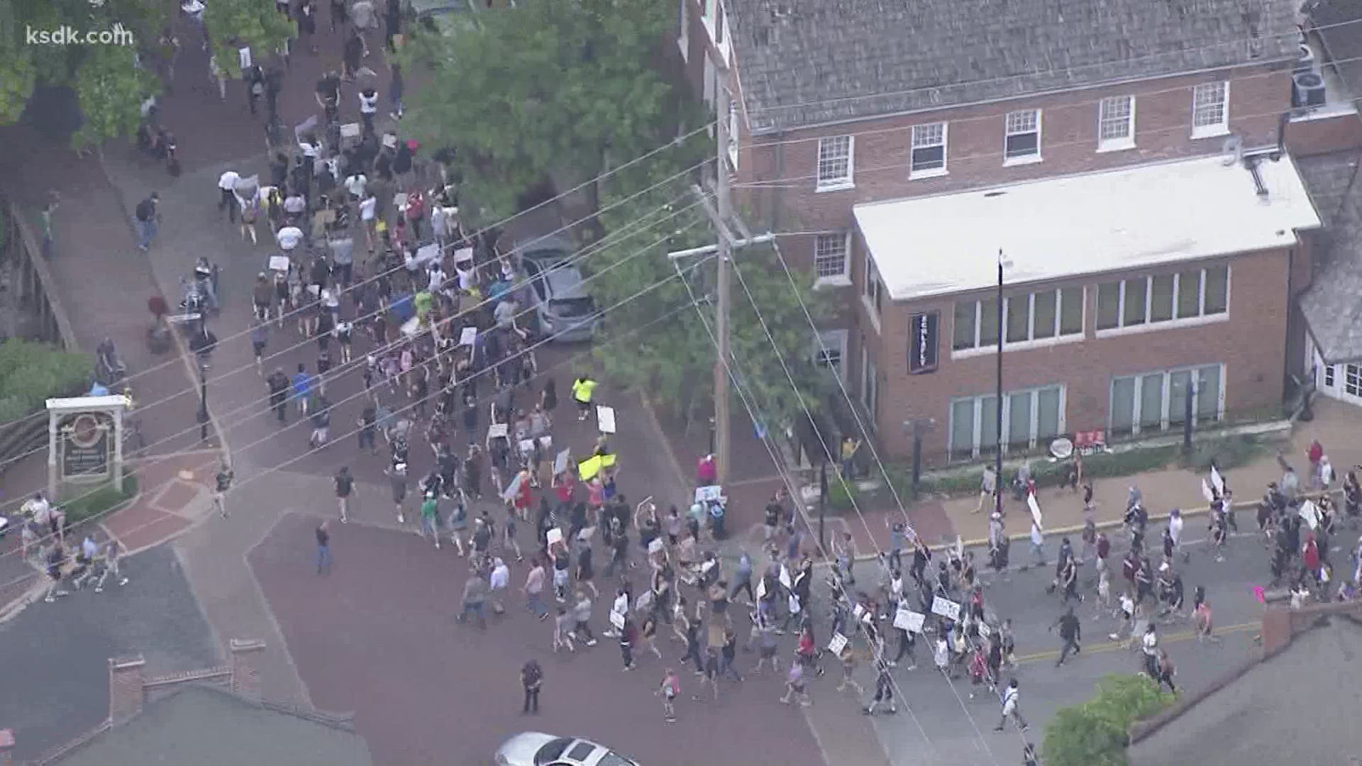 The police are walking with protesters along Main Street in St. Charles.